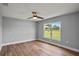 Cozy bedroom featuring a ceiling fan, hardwood floors, and a bright window at 1438 Mclin Dr, Plant City, FL 33565