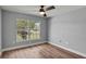 Bright bedroom with a ceiling fan, hardwood floors, and a large, bright window at 1438 Mclin Dr, Plant City, FL 33565