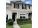 Inviting townhome exterior featuring tidy landscaping, neutral paint and a covered front porch at 5864 Fishhawk Ridge Dr, Lithia, FL 33547