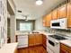 Bright kitchen featuring laminate countertops, wood cabinets, and white appliances at 5864 Fishhawk Ridge Dr, Lithia, FL 33547