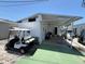 View of the carport of a mobile home featuring a golf cart, seating and parking at 10315 Cortez W Rd # 18D, Bradenton, FL 34210
