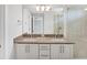 Bathroom featuring double sinks, granite countertops, modern lighting, and a glass-enclosed shower, exuding luxury and style at 3027 W Spruce St, Tampa, FL 33607
