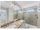 Modern bathroom featuring double sinks with granite countertops, a sleek glass shower, and contemporary fixtures, perfect for relaxation at 3027 W Spruce St, Tampa, FL 33607
