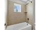 A bright bathroom featuring tile surround, tub, shower and a window at 3027 W Spruce St, Tampa, FL 33607