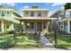 Charming two-story home with a well-manicured lawn and black metal fence at 3027 W Spruce St, Tampa, FL 33607