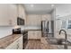 Close up of stainless steel appliances, granite countertops and sleek white backsplash in the kitchen at 3027 W Spruce St, Tampa, FL 33607