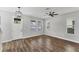 Bright living room with wood-look floors, large windows, and modern light fixture at 3027 W Spruce St, Tampa, FL 33607
