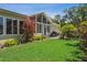 Expansive backyard with green grass, mature trees, grill, and large windows at 3404 W Villa Rosa St, Tampa, FL 33611