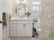 Well-lit bathroom with modern vanity, framed mirror, elegant wallpaper, and neutral colors at 3404 W Villa Rosa St, Tampa, FL 33611