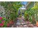 Stone path through lush, landscaped garden with flowering plants at 3404 W Villa Rosa St, Tampa, FL 33611