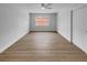 Bright bedroom with wood-look floors, ceiling fan, and large window at 3410 Grove Street Cir, Tampa, FL 33610