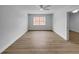 Well-lit bedroom with wood-look floors, a ceiling fan, and a large window at 3410 Grove Street Cir, Tampa, FL 33610