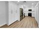Open kitchen showcasing stainless steel fridge, white cabinetry and wood-look flooring at 3410 Grove Street Cir, Tampa, FL 33610