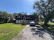 Two-story home with a front-facing garage, complemented by a long driveway and mature trees at 359 S Orchid Dr, Ellenton, FL 34222