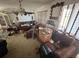 Spacious living room featuring a ceiling fan, chandelier, and multiple leather couches at 359 S Orchid Dr, Ellenton, FL 34222
