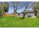 Spacious backyard with lush green grass, a wooden fence, and a patio with an outdoor dining set for entertaining at 3926 Helena Ne St, St Petersburg, FL 33703