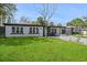 Charming single-story home with a well-maintained lawn, updated landscaping, and a light blue front door at 3926 Helena Ne St, St Petersburg, FL 33703