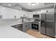 Modern kitchen featuring stainless steel appliances, white subway tile backsplash, and gray and white cabinets at 3926 Helena Ne St, St Petersburg, FL 33703