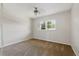 A cozy bedroom with plush carpet, a simple ceiling light, and a bright window at 1415 Doolittle Ln # 106, Dunedin, FL 34698