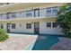Close up of the entrances to the condo units with manicured landscaping and walkways at 1415 Doolittle Ln # 106, Dunedin, FL 34698