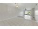 Bright living room featuring neutral tile flooring and a sliding glass door to the outside at 1415 Doolittle Ln # 106, Dunedin, FL 34698