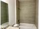 Clean bathroom featuring neutral tile, white tub, and granite countertop at 27206 Adams St, Punta Gorda, FL 33983