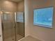 Bathroom features a glass-enclosed shower with tile surround and a window for natural light at 27206 Adams St, Punta Gorda, FL 33983