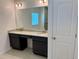 Bathroom with dual sink vanity, granite countertop, ample cabinet space, and a large mirror at 27206 Adams St, Punta Gorda, FL 33983