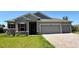 Charming single-story home with a three-car garage, stone accents, and a well-manicured lawn at 27206 Adams St, Punta Gorda, FL 33983