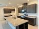 Modern kitchen features dark cabinetry, granite countertops, stainless steel appliances, and a spacious island at 27206 Adams St, Punta Gorda, FL 33983