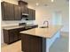 Modern kitchen features dark cabinetry, granite countertops, stainless steel appliances, and a spacious island at 27206 Adams St, Punta Gorda, FL 33983