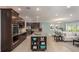 Open-concept kitchen featuring a large island with seating, dark wood cabinets, and stainless steel appliances at 27206 Adams St, Punta Gorda, FL 33983