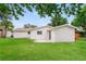 A spacious backyard with a lush green lawn and exterior view of a white home at 6426 Eden Ln, Tampa, FL 33634