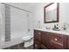 A bathroom featuring a wooden vanity and white tiled shower and tub at 6426 Eden Ln, Tampa, FL 33634