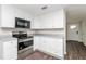 Efficient kitchen featuring white cabinets, stainless steel appliances, and durable gray countertops at 6426 Eden Ln, Tampa, FL 33634