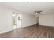 Spacious living room featuring modern floors, a ceiling fan, and a sliding glass door for natural light at 6426 Eden Ln, Tampa, FL 33634