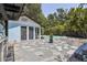 Landscaped backyard featuring a swimming pool, stone patio, and blue storage building at 6503 N Wellington Ave, Tampa, FL 33604