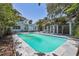 A serene backyard featuring a refreshing pool and lush tropical landscaping at 6503 N Wellington Ave, Tampa, FL 33604