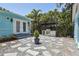 Backyard with outdoor kitchen, gravel landscaping, and small patio area, surrounded by tropical plants at 6503 N Wellington Ave, Tampa, FL 33604