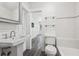 Bright bathroom with white subway tile, modern fixtures, and glass shelving for storage at 6503 N Wellington Ave, Tampa, FL 33604