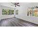 Light-filled bedroom with large windows providing lush green views and modern ceiling fan at 6503 N Wellington Ave, Tampa, FL 33604