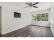 Comfortable bedroom featuring a ceiling fan, mounted tv, and a large window with natural light at 6503 N Wellington Ave, Tampa, FL 33604