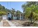 Light blue home featuring lush landscaping, mature trees, and charming curb appeal at 6503 N Wellington Ave, Tampa, FL 33604