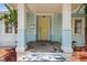 Inviting front porch with stone flooring, light blue pillars and light yellow door at 6503 N Wellington Ave, Tampa, FL 33604