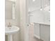Bathroom featuring a pedestal sink, with a chandelier lit room just outside the door at 7288 Deer Valley Circle, Tampa, FL 33635