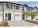 Modern townhouse showcasing a one-car garage, neutral color, and landscaped front yard at 7288 Deer Valley Circle, Tampa, FL 33635