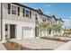 Modern townhouses showcasing a one-car garage, neutral color, and landscaped front yard at 7288 Deer Valley Circle, Tampa, FL 33635