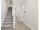 Light-filled hallway with neutral walls and flooring leads to carpeted stairs, enhancing the home's bright and welcoming interior at 7288 Deer Valley Circle, Tampa, FL 33635
