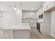 White kitchen features a large island with stone countertop, modern appliances, and pendant lighting at 7288 Deer Valley Circle, Tampa, FL 33635