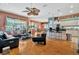 Open concept living room with hardwood floors connecting to the kitchen and offers views of the outdoor pool and patio at 14680 Linden Dr, Spring Hill, FL 34609